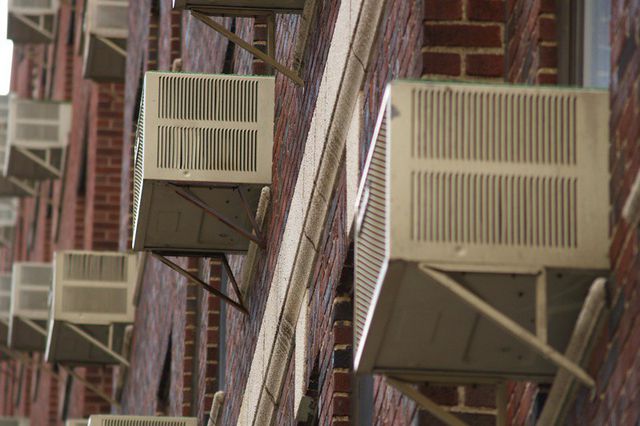 Rows of air conditioners hang outside apartment windows in Brooklyn.